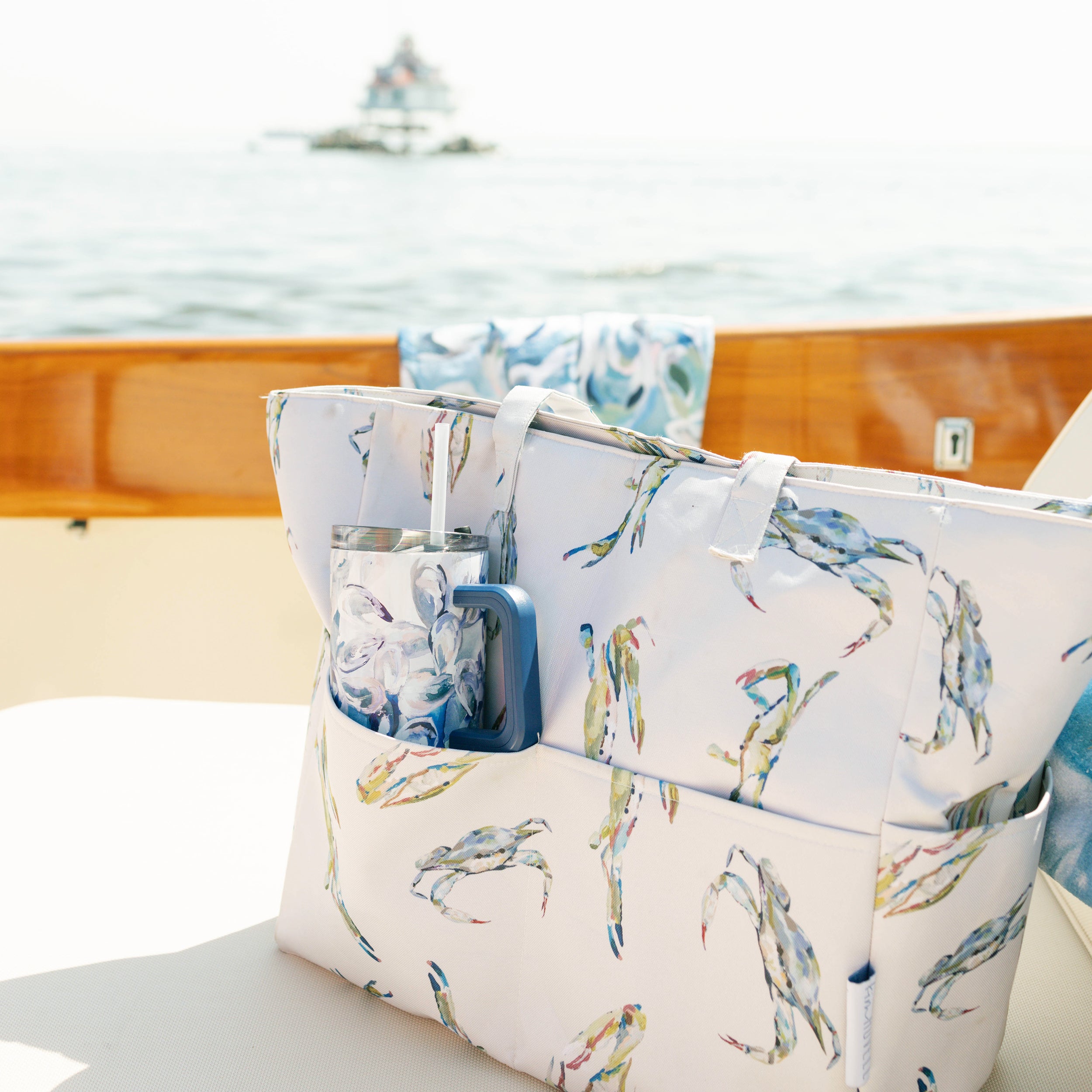 Kim Hovell blue oyster shell pattern 40 ounce tumbler in a tote bag on a small picnic yacht