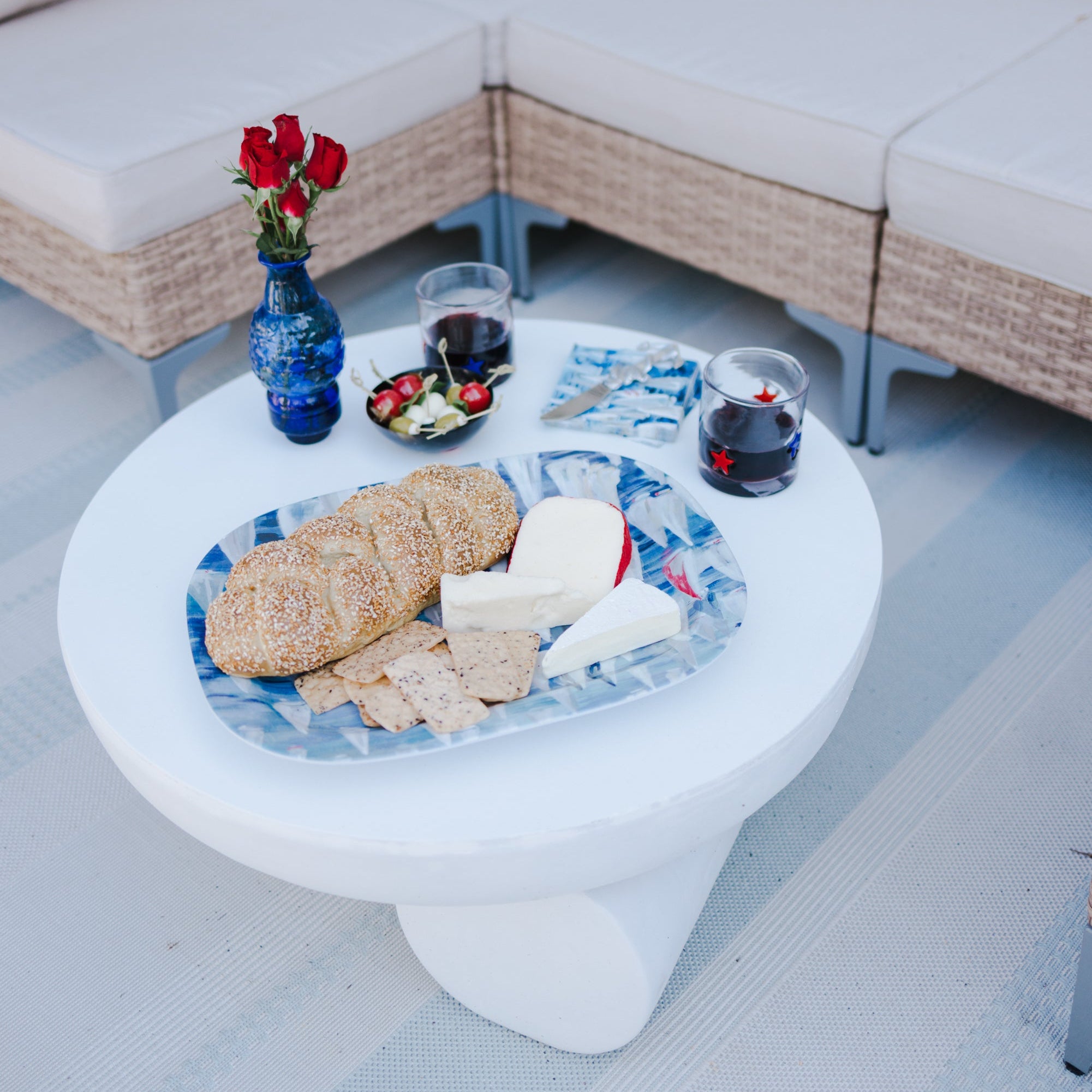 Outdoor setting with a sectional sofa, small table with snacks, and drinks on a patio.