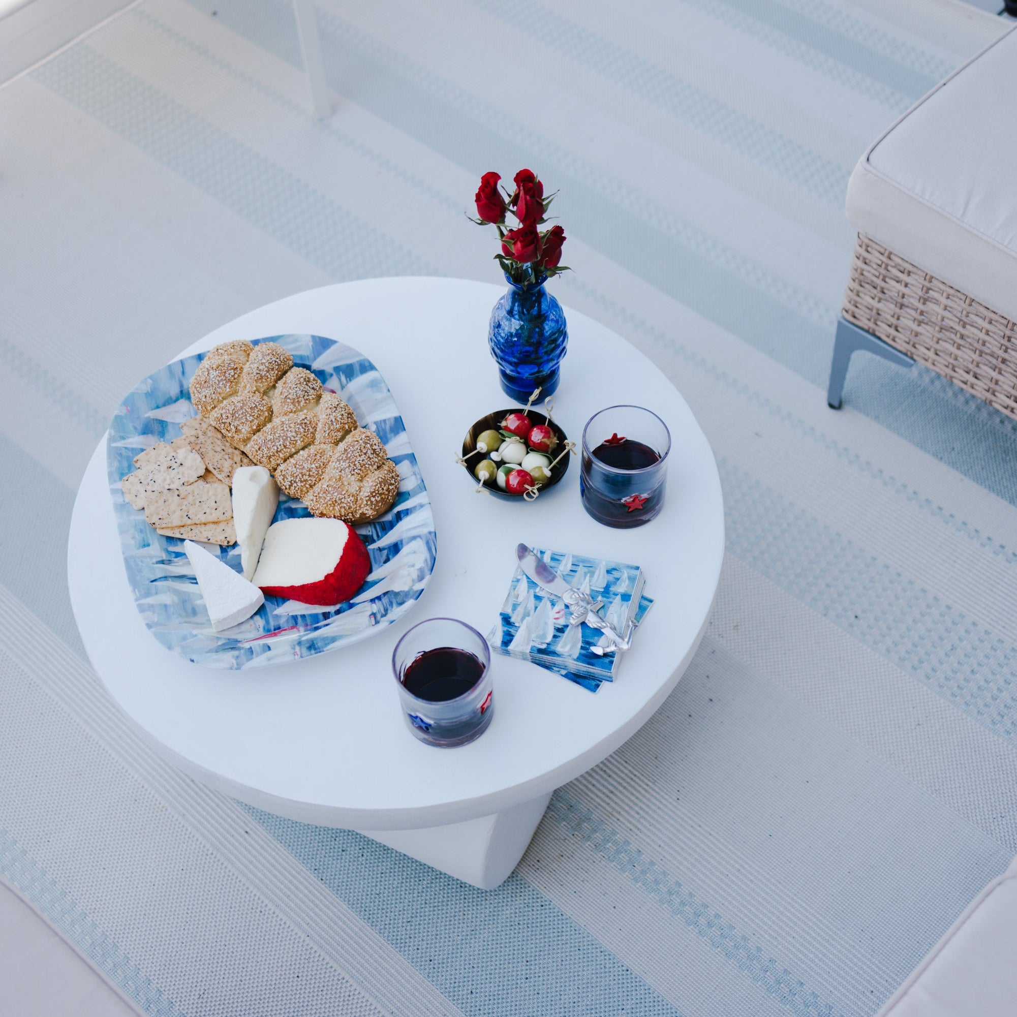 Small round table with snacks and drinks on a patio