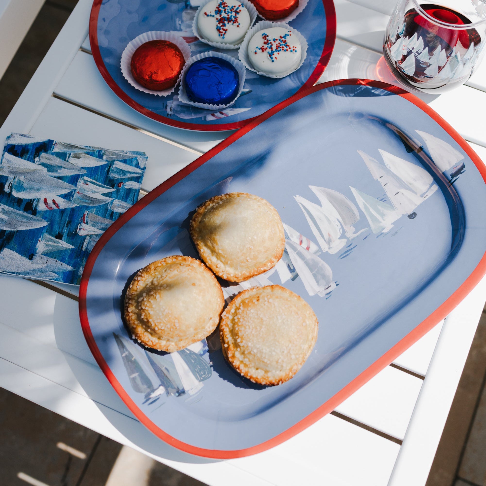 Tray with cookies and a glass of red wine on a table