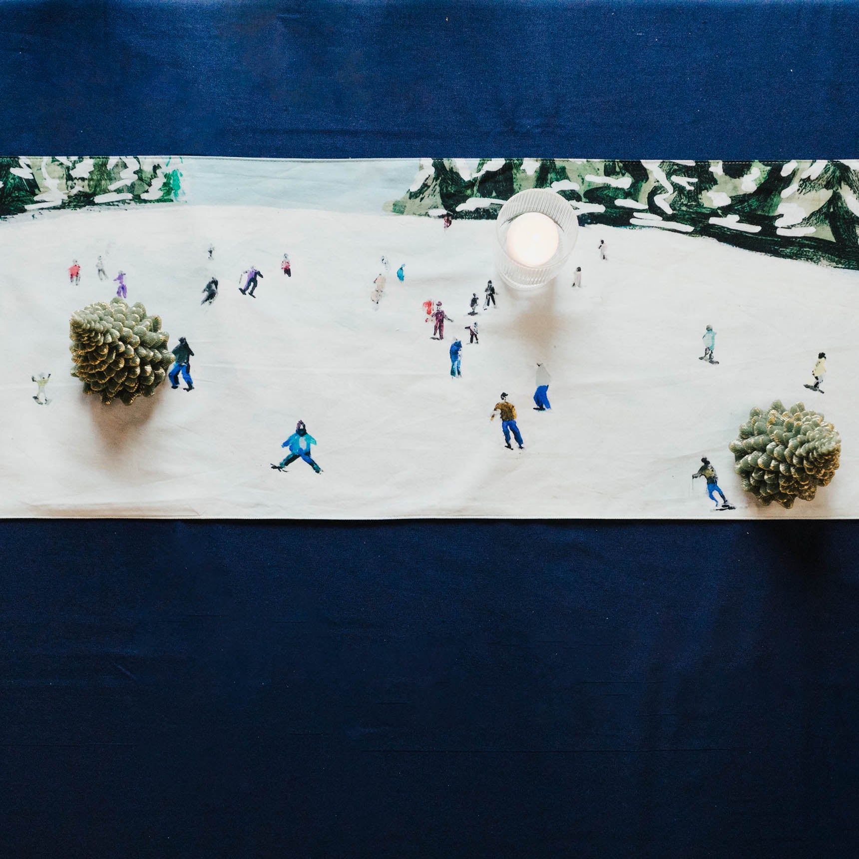 Table setting with miniature ski figures on a snowy scene tablecloth