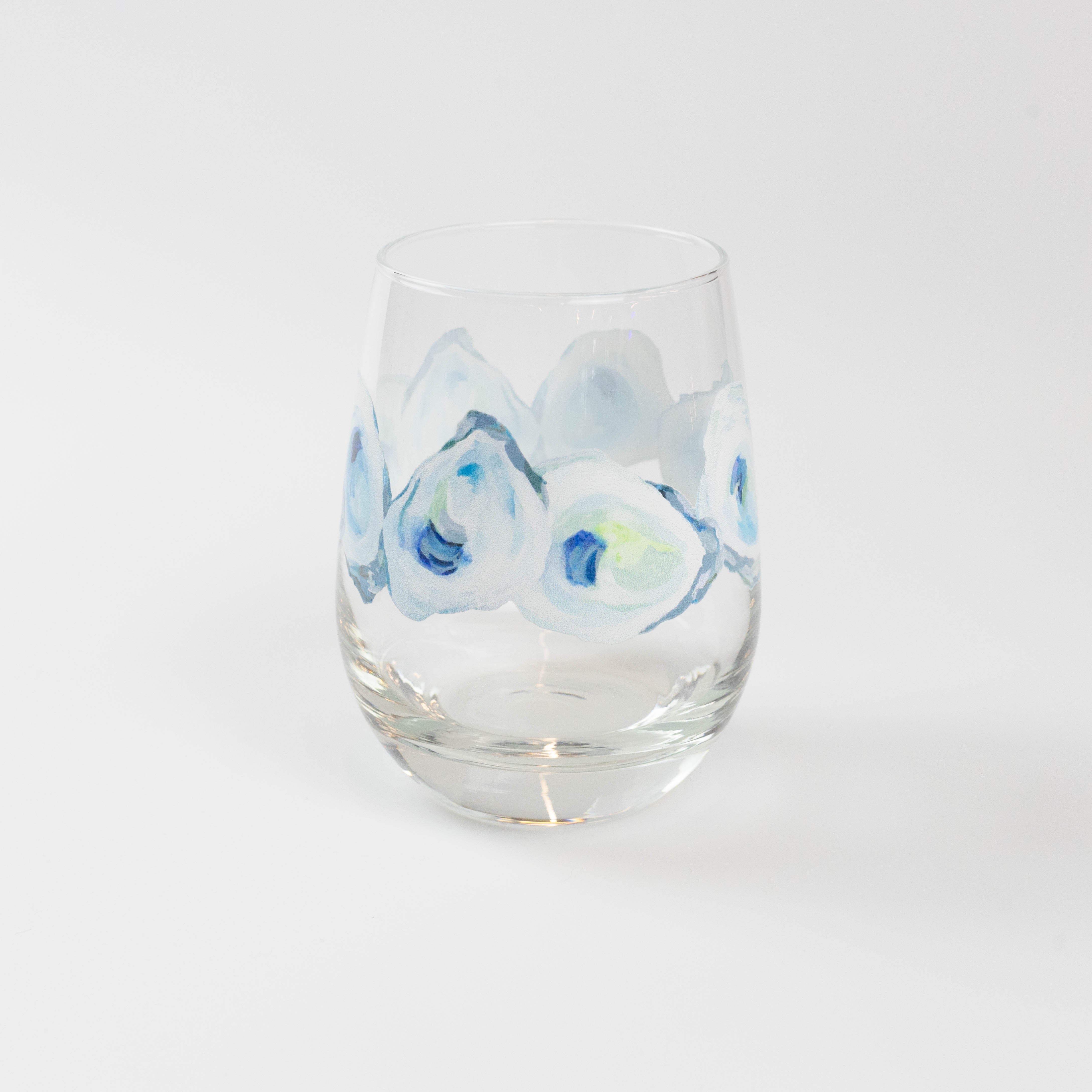 Kim Hovell blue and white oyster design adorning a stemless wine glass against a white background.