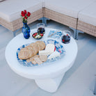 Outdoor setting with a sectional sofa, small table with snacks, and drinks on a patio.