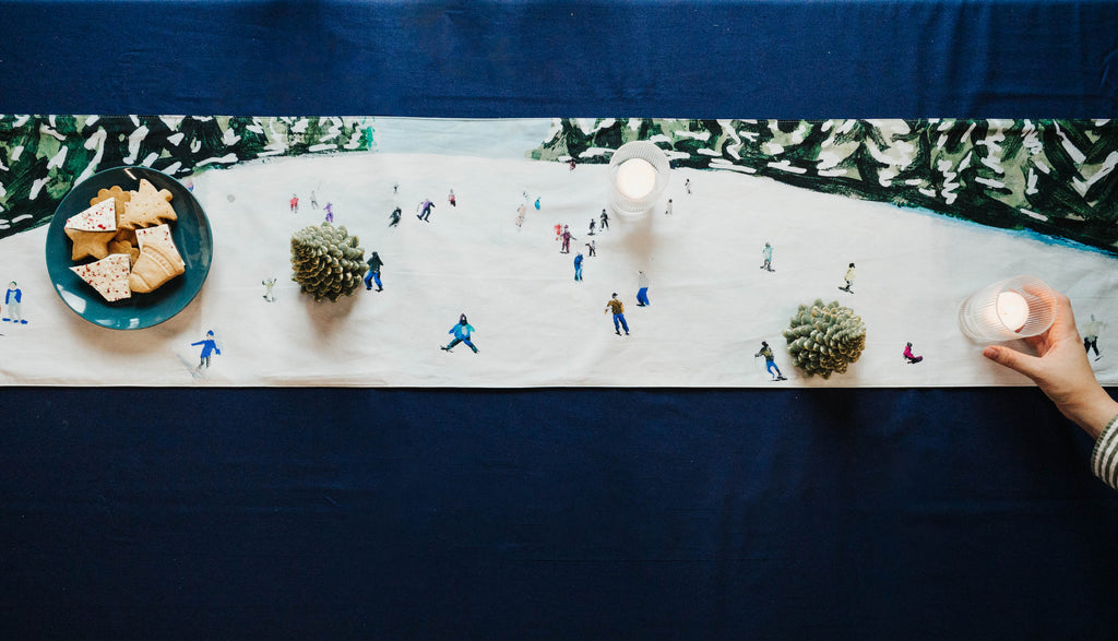 Table setting with miniature ski figures on a snowy scene tablecloth