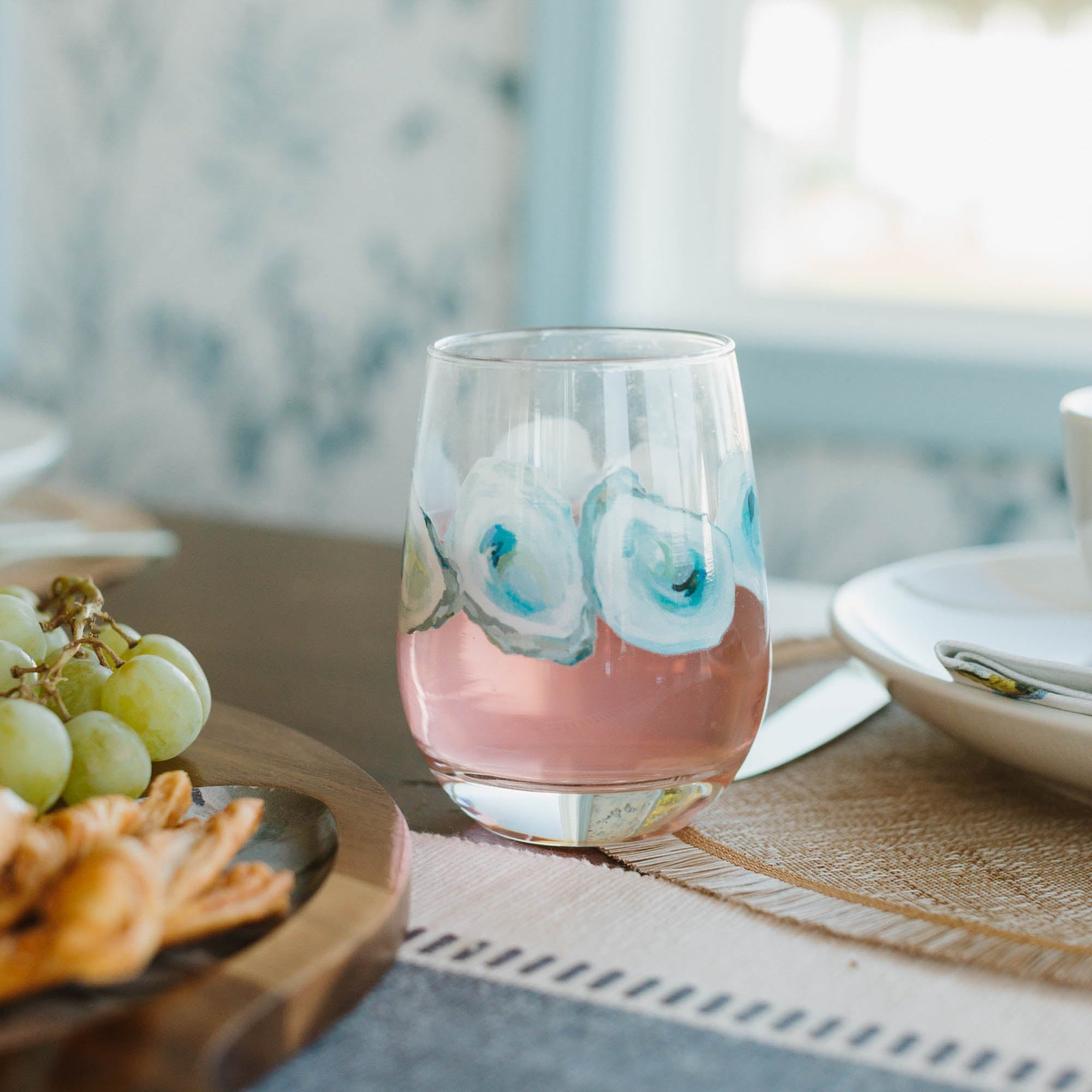 Kim Hovell stemless oyster pattern glass on a dining table set with a charcuterie board 