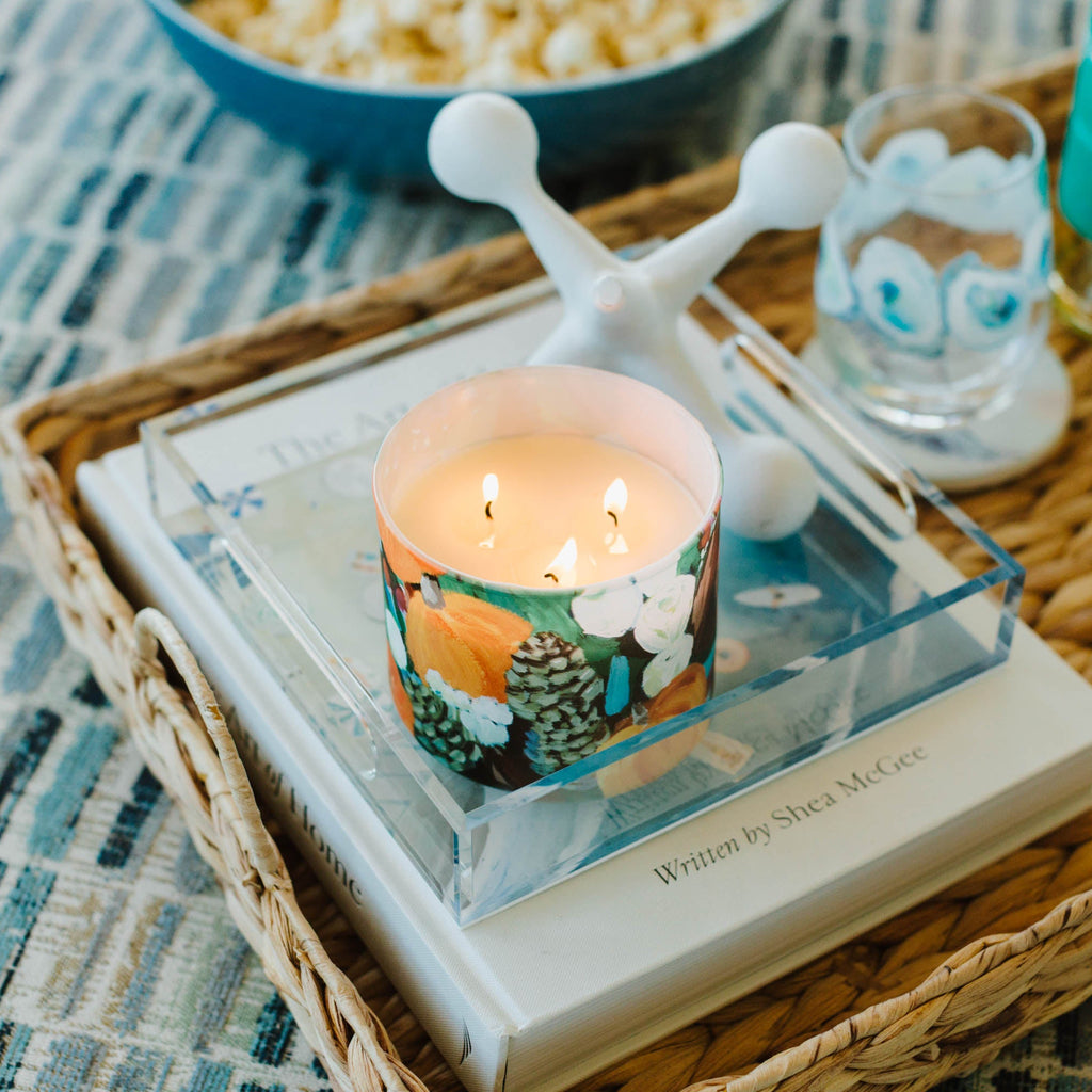 Fall candle on a book with popcorn and drinks in the background