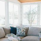 Living room with a sectional sofa, ottoman, and decorative pillows.