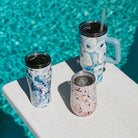 Three insulated Kim Hovell tumblers with shell prints on a pool diving board