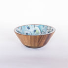 A medium-sized wooden bowl with blue and white oyster patterned interior designed by Kim Hovell, placed against a white background.