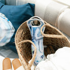Woven bag with a blue and white oyster patterned wine tote bag designed by Kim Hovell on a picnic boat. 