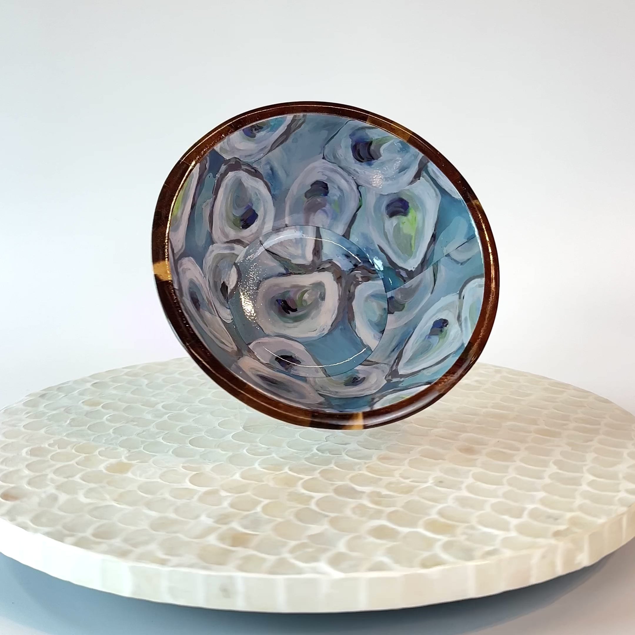 video featuring rotating display of Kim Hovell acacia wood bowl with blue and white oyster pattern interior design. 