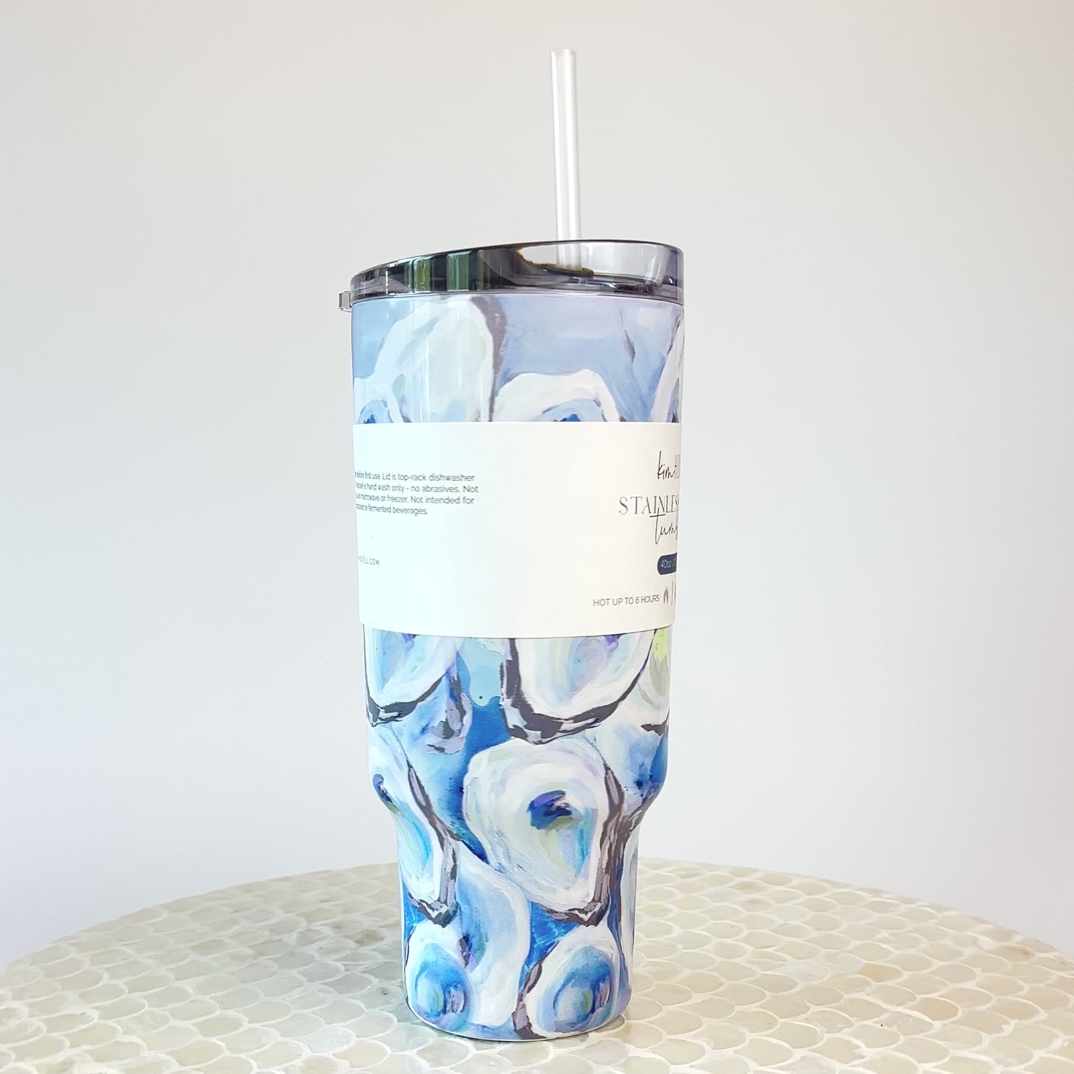 A video of a rotating blue and white oyster pattern 40oz tumbler with a handle and a straw, against a white background.