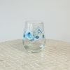 video featuring a rotating Kim Hovell blue and white oyster design adorning a stemless wine glass against a white background. 